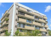 Multi-story building with multiple balconies and neutral-colored exterior paint on a clear day at 799 Dahlia St # 201, Denver, CO 80220