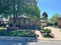 Charming single-story brick home with mature trees and a well-maintained front yard at 2124 S Yates St, Denver, CO 80219