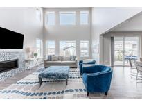 Bright living room with high ceilings, fireplace, comfortable seating, and many windows at 211 Luna Ct, Erie, CO 80516