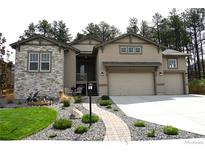 Charming home featuring a three-car garage and beautifully landscaped front yard at 878 Tree Bark Ter, Colorado Springs, CO 80132