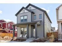 Charming two-story home features a covered porch with seating, and neutral gray siding at 6315 N Emporia St, Denver, CO 80238