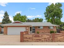 Charming brick ranch home featuring an attached garage and well maintained front yard at 8205 Pennsylvania St, Denver, CO 80229
