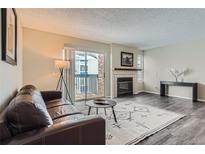 Inviting living room with cozy fireplace, sliding glass doors, and sleek hardwood floors at 1312 S Cathay Ct # 202, Aurora, CO 80017