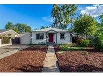 Charming single-story home featuring a red door, manicured lawn, and a concrete pathway at 2658 W 1St Ave, Denver, CO 80219