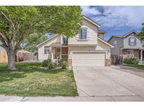 Charming two-story home featuring a well-manicured lawn and a spacious two car garage at 9882 Harris St, Thornton, CO 80229