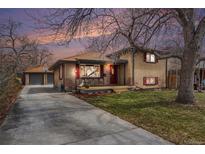 Charming brick home with mature trees, a front porch, a long driveway and a detached garage at 7930 Quitman St, Westminster, CO 80030
