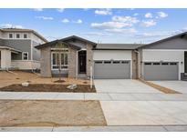 Charming single Gathering home featuring brick accents, a two car garage, and landscaping at 6615 N Nepal St, Aurora, CO 80019