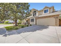 Charming two-story home with brick and siding, a well-manicured lawn, and an attached two-car garage at 5604 S Lisbon Way, Centennial, CO 80015