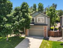 Charming two-story home with a well-maintained lawn, mature trees, and an attached two-car garage at 2548 Foothills Canyon Ct, Highlands Ranch, CO 80129