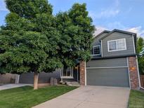 Charming two-story home with a mature shade tree and a well-maintained lawn at 2548 Foothills Canyon Ct, Highlands Ranch, CO 80129