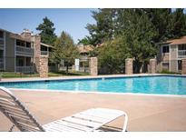 Inviting community pool with lounge chairs, perfect for relaxing and enjoying the outdoors at 8225 Fairmount Dr # 10-203, Denver, CO 80247