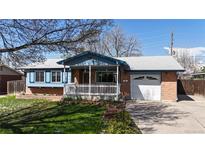 Charming single-Gathering home featuring a brick exterior, a cozy front porch with a white picket fence, and a well-manicured lawn at 921 S Wheeling St, Aurora, CO 80012