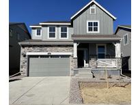 Charming two-story home featuring stone accents and a welcoming front porch, perfect for relaxing outdoors at 729 N Deer Park St, Watkins, CO 80137