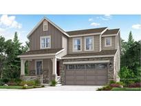 Beautiful two-story home with stone accents, covered porch and two car garage, surrounded by lush landscaping at 729 N Deer Park St, Watkins, CO 80137