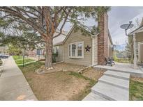 Charming home exterior showcasing a well-maintained yard and mature tree in a quiet neighborhood at 9689 W Chatfield Ave # H, Littleton, CO 80128