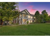 Charming condo building with lush green lawn, mature trees, and inviting covered porch and upper balcony at 4385 S Balsam St # 10-103, Littleton, CO 80123