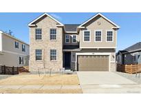 Charming two-story home featuring a two car garage, neutral colors, and professionally landscaped front yard at 660 Apex Rise St, Erie, CO 80516