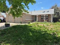 Charming exterior elevation showcasing the home's brick facade and well-maintained front yard and two car garage at 4296 S Halifax Way, Aurora, CO 80013