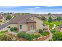 Inviting single-story home with landscaped front yard and stone accents, offering accessibility with a convenient ramp at 22124 E Euclid Dr, Aurora, CO 80016