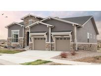 Beautiful two-story home featuring a two-car garage and stone and gray siding at 22364 E Bailey Pl, Aurora, CO 80016