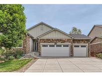 Charming home exterior with a three car garage, stone accents, and well-maintained landscaping at 162 N Eaton Park St, Aurora, CO 80018