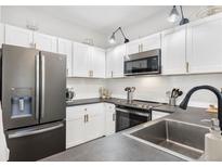 Modern kitchen featuring white cabinets, stainless steel appliances, and sleek countertops at 4085 S Crystal Cir # 101, Aurora, CO 80014