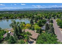 Breathtaking aerial view of a lakeside home surrounded by lush greenery and distant mountain views at 4790 W Lakeridge Rd, Denver, CO 80219