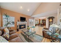 Spacious living room with hardwood floors, fireplace, and access to backyard at 9875 Greensview Cir, Lone Tree, CO 80124