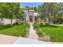 Charming home featuring a stone facade, a well-manicured lawn and mature trees at 11638 Xavier Way, Westminster, CO 80031
