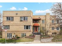 Multi-Gathering apartment building with brick facade, landscaped entry, and distinctive awnings over the main doorway at 3905 E 2Nd Ave # 2, Denver, CO 80206