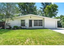 Charming single-story home with well-maintained front yard, lush lawn, and mature shade trees at 1360 S Hudson St, Denver, CO 80222