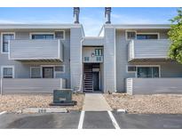 Apartment building exterior with gray siding, balconies, and an open stairway at 10150 E Virginia Ave # 11-202, Denver, CO 80247