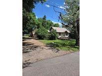 Charming single-Gathering home with mature trees, a gravel driveway and classic architectural details at 2350 / 2352 Garland St, Lakewood, CO 80215