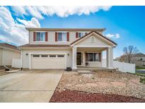 Two-story home with white siding, red shutters, covered porch and an attached two-car garage at 5178 Netherland St, Denver, CO 80249