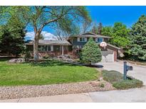 Charming two-story home with a well-maintained lawn, mature trees and a basketball hoop above the garage at 7521 S Race St, Centennial, CO 80122