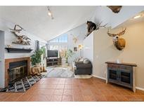 Inviting living room featuring a fireplace, vaulted ceiling and unique animal display at 4086 S Carson St # F, Aurora, CO 80014
