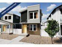 New construction shows a modern two-story home with a mix of siding, a bright yellow door, and a small tree in the yard at 10366 Uvalda Ct, Commerce City, CO 80022