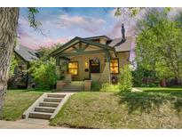 Charming front exterior features a covered porch, brick facade, and well-maintained landscaping with mature trees and manicured lawn at 2236 Forest St, Denver, CO 80207