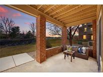 A cozy patio with brick pillars offers tranquil outdoor seating and scenic views of the surrounding landscape at 12924 Ironstone Way # 103, Parker, CO 80134