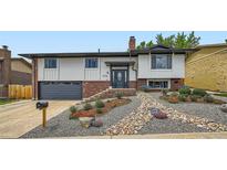 Inviting home exterior featuring manicured rock garden, modern front door, and attached garage at 2176 S Welch Cir, Lakewood, CO 80228