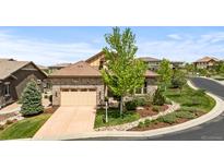 Charming home with a stone facade, tile roof, and well-manicured front yard at 671 Hiddenbrook Ct, Littleton, CO 80126