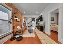 Open-concept living room featuring hardwood floors and ample natural light at 1208 S Pennsylvania St, Denver, CO 80210