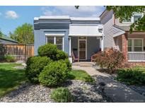 Charming blue home with manicured front yard, lush green bushes, and rock landscaping at 2643 N Marion St, Denver, CO 80205
