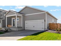 Charming home featuring a two-car garage, well-maintained lawn and covered front porch at 7208 Dolores Ave, Frederick, CO 80530