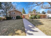 Charming two-story home with a walkway leading to a red front door and a well-manicured lawn at 3883 S Elm St, Denver, CO 80237