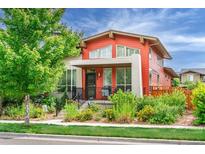 Charming two-story home with orange siding, inviting front porch, and well-manicured landscaping at 2868 Kingston St, Denver, CO 80238