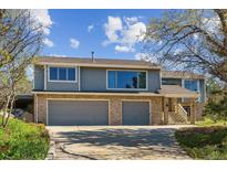 Charming two-story home boasts a brick-accented facade and attached two-car garage, set beneath a bright blue sky at 53 Taylor Ct, Castle Rock, CO 80104