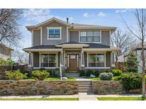 Charming two-story home with stone accents, lush landscaping, and inviting front porch, perfect for curb appeal at 1644 S Lafayette St, Denver, CO 80210