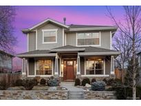 Stunning two-story home featuring a welcoming front porch, stone accents, and beautiful landscaping at 1644 S Lafayette St, Denver, CO 80210