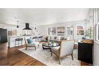 Bright, airy living room with modern decor, featuring hardwood floors and large windows for natural light at 11640 W 13Th Ave, Lakewood, CO 80401